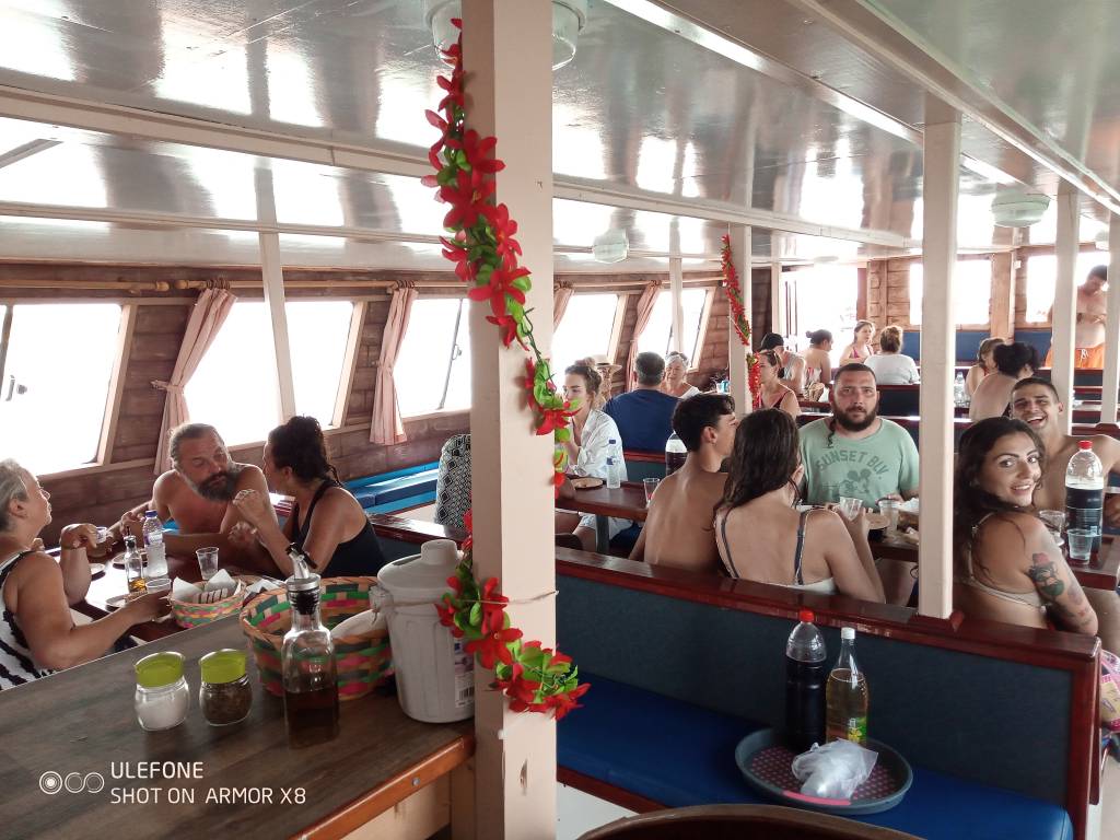 People dining and socializing inside a boat's cabin, enjoying a lively atmosphere